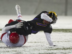 STM's Spencer Moore tackles Mt. Doug's Seye Farinu on snowy UBC Thunderbird Stadium turf during Subway Bowl semifinals this past November. (PNG file photo)