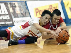 Santi Ubial (left) of the Tupper Tigers, battles for a loose ball with JJ Deslauriers of the St. Thomas More Knights during senior boys Triple A action Jan. 31 at UBC’s War Memorial Gym. Tupper won 60-59 and moved into the No. 1 spot in the provincial rankings for the first time in school history. (Wilson Wong, UBC athletics)