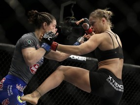 Ronda Rousey, right, kicks Sara McMann during a UFC 170 mixed martial arts women's bantamweight title fight on Saturday, Feb. 22, 2014, in Las Vegas. Rousey won by TKO. (AP Photo/Isaac Brekken) ORG XMIT: NVIB111