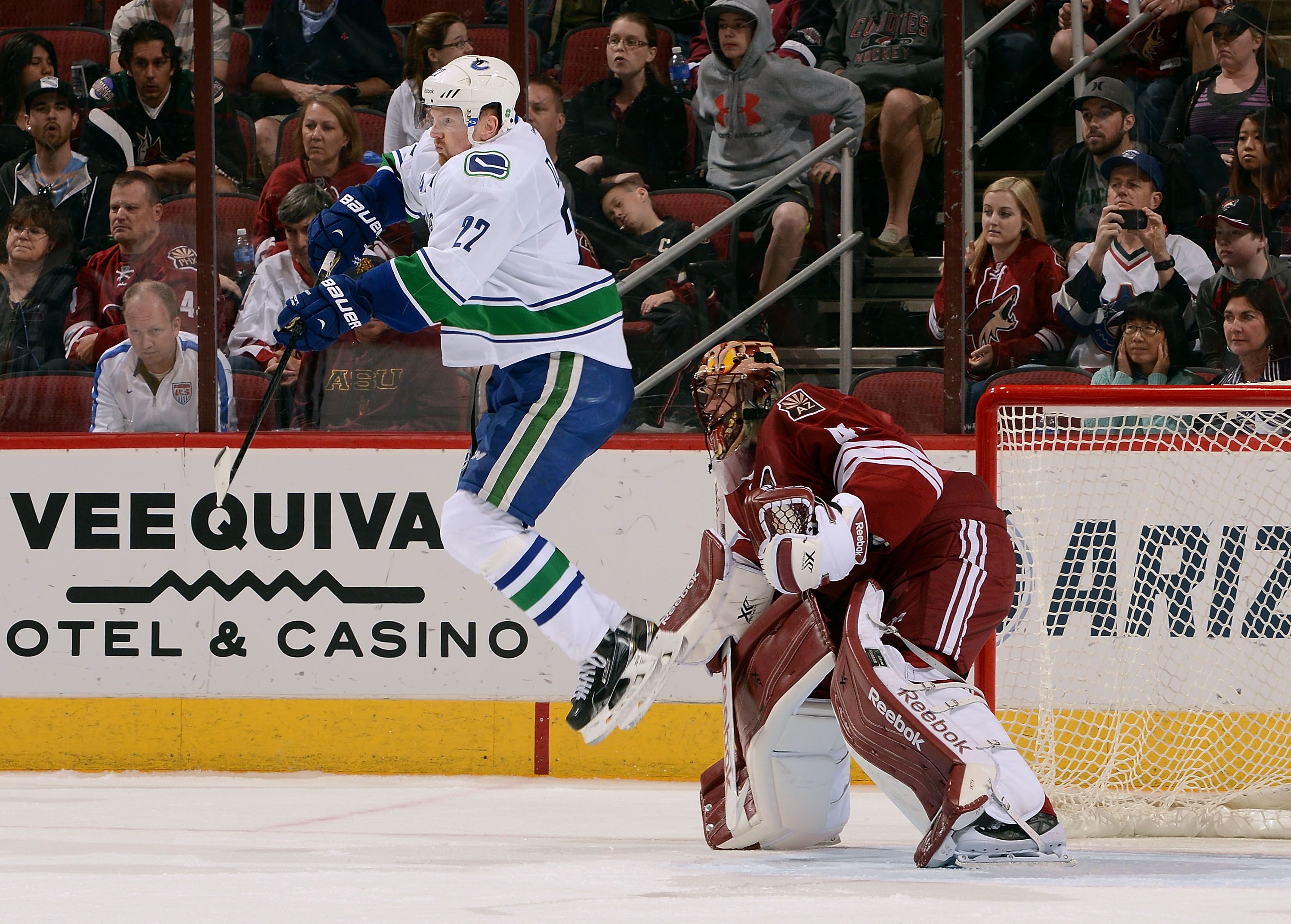 GLENDALE, AZ - MARCH 22:  Daniel Sedin #22 of the Vancouver Canucks leaps to re-direct the puck in front of goaltender Mike Smith #41 of the Arizona Coyotes during the third period at Gila River Arena on March 22, 2015 in Glendale, Arizona.  (Photo by Norm Hall/NHLI via Getty Images)