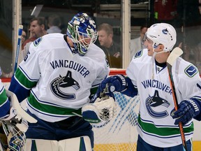 Alex Burrows hands the game puck to Jacob Markstrom after a 3-1 victory against the Arizona Coyotes Sunday. ( (Photo by Norm Hall/NHLI via Getty Images)