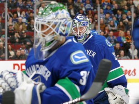 Eddie Lack and Jacob Markstrom get ready to switch places in the Canucks' loss to the Sharks on Tuesday. (Getty Images.)