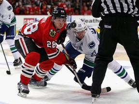 Ben Smith, back in his Blackhawk days, duels with Canucks captain Henrik Sedin. Smith was moved to San Jose Monday.  (Getty Images file.)