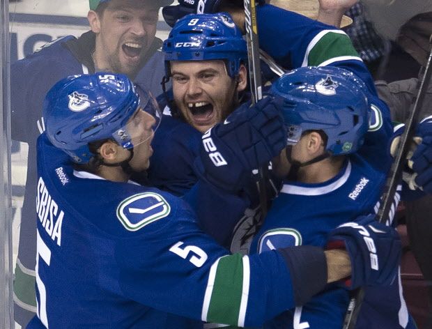 Vancouver Canucks right wing Zack Kassian (9) celebrates his goal with teammates Luca Sbisa (5) and Dan Hamhuis (2) during the third period of NHL action against Anaheim Ducks in Vancouver, B.C. Monday, March 9, 2015. Kassian's goal would stand as the eventual game winner as the Canucks beat the Ducks 2 -1. THE CANADIAN PRESS/Jonathan Hayward