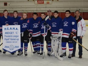 Isaac Clark (on left behind the banner), his teammates and coaches pose after placing second in the playoffs of their Pacific Coast Amateur Hockey Association midget group.