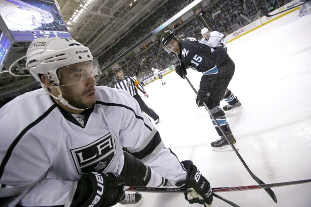Los Angeles Kings left wing Dwight King (74) vies for the puck along the boards against San Jose Sharks left wing James Sheppard (15) during the first period of Game 4 of an NHL hockey first-round playoff series in San Jose, Calif., Saturday, April 26, 2014. (AP Photo/Tony Avelar)