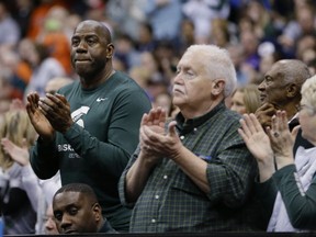 Magic Johnson, left, cheers with other Michigan State fans during the second half of Michigan State's regional semifinal against Oklahoma in the NCAA men's college basketball tournament  Friday, March 27, 2015, in Syracuse, N.Y. (AP Photo/Seth Wenig)