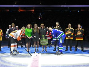 Pat Quinn's daughters Val (l) and Kalli (r), and granddaughter Kate Rydland participate in the ceremonial face-off with Claude Giroux of the Flyers and Henrik Sedin of the Canucks before Tuesday's game at Rogers Arena. Former Canucks in the background include (l to r) Stan Smyl, Markus Naslund, Trevor Linder, Kirk McLean and Pavel Bure. (Photo by Jeff Vinnick/NHLI via Getty Images)