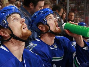 VANCOUVER, CANADA - NOVEMBER 15:  Daniel Sedin #22 (L) and his twin brother Henrik Sedin #33 of the Vancouver Canucks sit on the bench during their game against the Toronto Maple Leafs at General Motors Place on November 15, 2008 in Vancouver, British Columbia, Canada.  The Canucks won 4-2.   (Photo by Jeff Vinnick/NHLI via Getty Images) [PNG Merlin Archive]