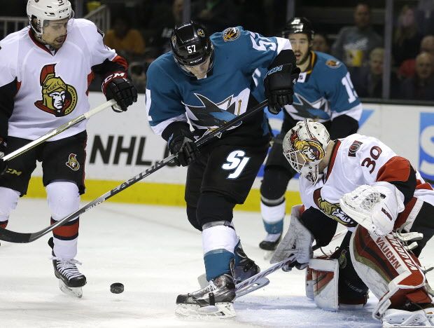 San Jose Sharks' Tommy Wingels (57) looks for the puck which was deflected off Ottawa Senators goalie Andrew Hammond, right, during the first period of an NHL hockey game Saturday, Feb. 28, 2015, in San Jose, Calif. Sharks' Wingels scored on the play. At left is Ottawa's Cody Ceci. (AP Photo/Ben Margot)