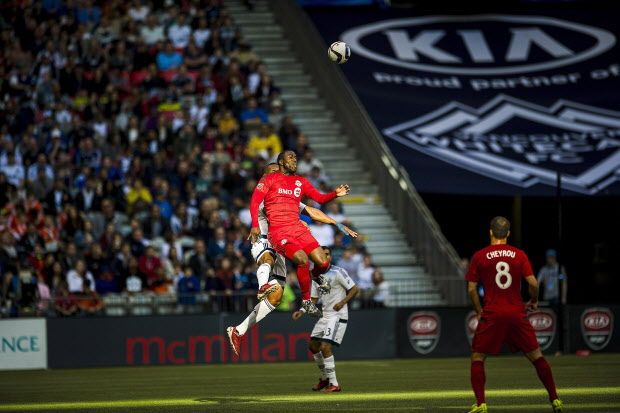 Vancouver Whitecaps' Kendall Waston (4), left, goes up for the ball against Toronto FC forward Jozy Altidore (17) as Vancouver FC defender Sam Adekugbe (3) and Toronto midfielder Benoit Cheyrou look on during the first half of an MLS soccer game in Vancouver, B.C., on Saturday, March 7, 2015. THE CANADIAN PRESS/Jimmy Jeong