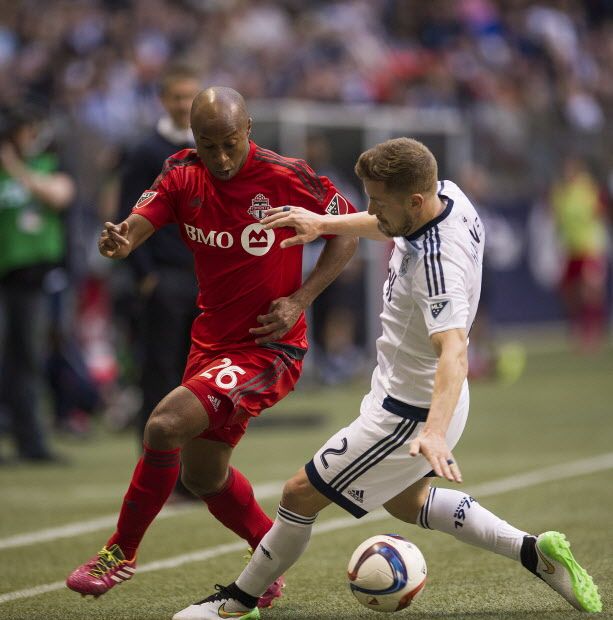 Toronto FC midfielder Collen Warner (26), left, challenges Vancouver FC defender Jordan Harvey (2) during the second half of an MLS soccer game in Vancouver, B.C., on Saturday, March 7, 2015. Toronto defeated Vancouver with a score of 3-1. THE CANADIAN PRESS/Jimmy Jeong