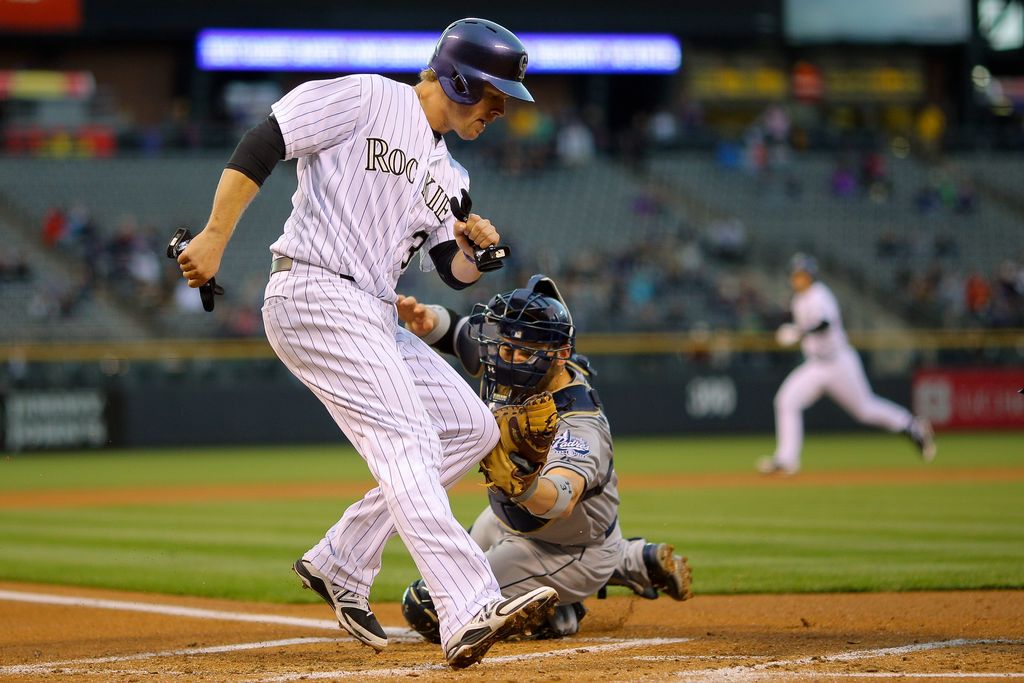 DENVER, CO - APRIL 22:  Justin Morneau #33 of the Colorado Rockies avoids the tag by catcher Derek Norris #3 of the San Diego Padres to score during the first inning at Coors Field on April 22, 2015 in Denver, Colorado. (Photo by Justin Edmonds/Getty Images)