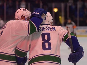 Alex Biega (left) gives Alex Friesen a pat on the head. They and their teammates are the first AHL team to clinch a playoff spot.