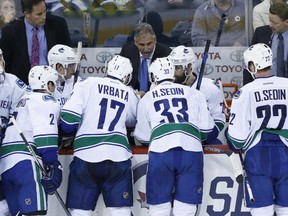 Vancouver Canucks head coach Willie Desjardins talks to his players during a timeout with 13 seconds left in period NHL action against the Winnipeg Jets in Winnipeg on Saturday, April 4, 2015. THE CANADIAN PRESS/John Woods