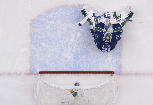 Vancouver Canucks goalie Eddie Lack (31) sits on the ice after being scored on by Calgary Flames defenseman Kris Russell (4) during the third period of NHL playoff action in Vancouver, B.C. Wednesday, April 15, 2015. THE CANADIAN PRESS/Jonathan Hayward