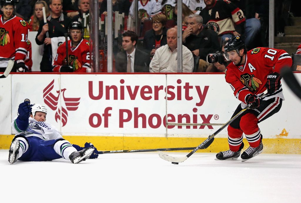 Think the University of Phoenix might try to claim that Chicago's Patrick Sharp is a grad and Vancouver's Derek Dorsett is not? Maybe. As well, why aren't those people in the stand watching the puck carrier? Strange, strange night. (Getty Images.)