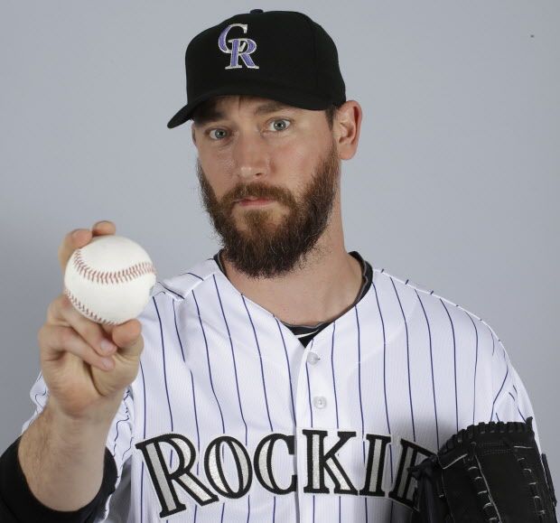 FILE - In a March 2015 file photo, John Axford of the Colorado Rockies baseball team poses for a photo in Scottsdale, Ariz. Axford's 2-year-old son is improving following a rattlesnake bite. Jameson Axford remained hospitalized for an eighth straight day, but Axford said Wednesday, Apri his son was able to sleep through the night as he deals with pain. Doctors have saved his right foot, but there is fear one of his toes may need to be amputated. 