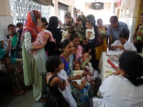 Indian women wait to get their infants immunized April 11 as part of a nationwide immunization drive at a government hospital in Allahabad, India. The campaign aims to immunize all children against seven vaccine-preventable diseases, including tetanus, diphtheria, whooping cough, polio, tuberculosis, measles and hepatitis. The authors of op-ed below are urging Canadians to help fund similar vaccination drives against tetanus in five developing nations this year and next.
(THE ASSOCIATED PRESS)