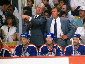 Glen Sather head coach and assistant coach John Muckler of the Edmonton Oilers direct action from behind bench against the Boston Bruins at Boston Garden.  (Photo by Steve Babineau/NHLI via Getty Images)