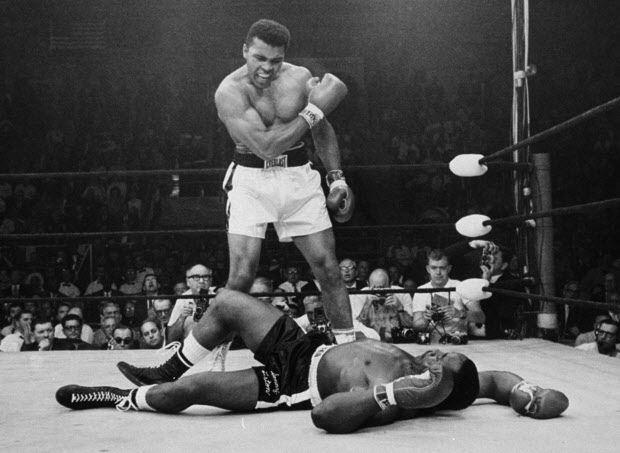 FILE - In this May 25, 1965, file photo, heavyweight champion Muhammad Ali stands over fallen challenger Sonny Liston, shouting and gesturing shortly after dropping Liston with a short hard right to the jaw in the first round of their title fight in Lewiston, Maine. The bout produced one of the strangest finishes in boxing history as well as one of sports most iconic moments. (AP Photo/John Rooney, File)