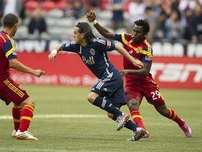 Mauro Rosales slips between a pair of RSL players. The Caps' veteran Argentine midfield is likely to start in Denver on Saturday. (Gerry Kahrmann  /  PNG staff photo)