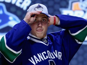 Jake Virtanen slips on a Canucks cap at the 2014 NHL draft in Philadelphia.