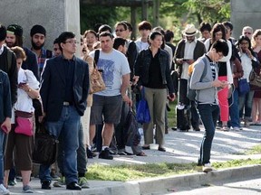 Commuters line up at Joyce-Collingwood SkyTrain station for temporary bus service after an overnight fire closed the line between Joyce and Waterfront in Vancouver Friday, May 22.  (Nick Procaylo, PNG)