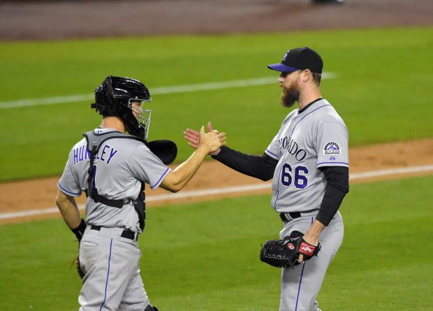 Colorado Rockies relief pitcher John Axford, right, and catcher Nick Hundley congratulate each other after defeating the Los Angeles Dodgers 5-4 in a baseball game, Thursday, May 14, 2015, in Los Angeles. (AP Photo/Mark J. Terrill)