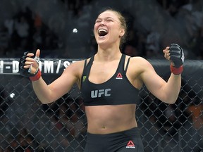 FILE - In this Feb. 28, 2015 file photo, Ronda Rousey, with Reebok insignia on her uniform, celebrates after defeating Cat Zingano in a UFC 184 mixed martial arts bantamweight title bout in Los Angeles. UFC fighters will be paid for wearing Reebok gear based on their tenure in the octagon under the mixed martial arts promotions new sponsorship deal. The UFC on Wednesday, May 6, 2015, announced the change in its pay structure for its deal with Reebok, which signed on late last year to outfit every fighter. (AP Photo/Mark J. Terrill, File)