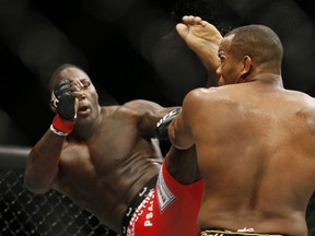 Anthony Johnson kicks Daniel Cormier during their light heavyweight title mixed martial arts bout at UFC 187 on Saturday, May 23, 2015, in Las Vegas. (AP Photo/John Locher)