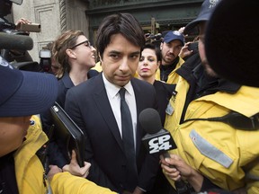 Jian Ghomeshi is escorted by police out of court past members of the media in Toronto on November 26, 2014.  Photo: THE CANADIAN PRESS/Darren Calabrese