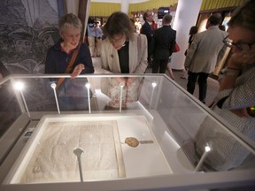 Liz Branigan, left, conservator at Durham Cathedral and Canon Rosalind Brown, librarian at Durham Cathedral, view copy of Magna Carta June 11 in Gatineau, Que. (THE CANADIAN PRESS)