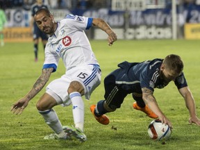 Vancouver Whitecaps defender Jordan Harvey, right, is knocked off the ball by Montreal Impact forward Andres Romero during second half MLS action Wednesday, June 3, 2015 in Montreal. THE CANADIAN PRESS/Paul Chiasson