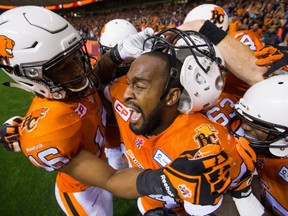 B.C. Lions' Bryan Burnham, left, and Emmanuel Arceneaux, centre, celebrate Arceneaux's winning touchdown during overtime CFL football action against the Saskatchewan Roughriders in Vancouver, B.C., on Friday July 10, 2015. THE CANADIAN PRESS/Darryl Dyck