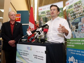 Employment Minister Pierre Poilievre, right, talks about the increased payments to families as part of the Universal Child Care Benefit as Conservative MP Keith Ashfield looks on during a press conference in Fredericton, N.B., on Thursday, July 23, 2015. THE CANADIAN PRESS/James West