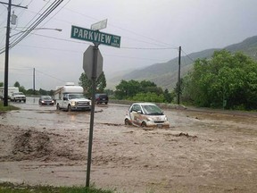 Cars try to navigate the flood zone on Westsyde Road in Kamloops on Tuesday.