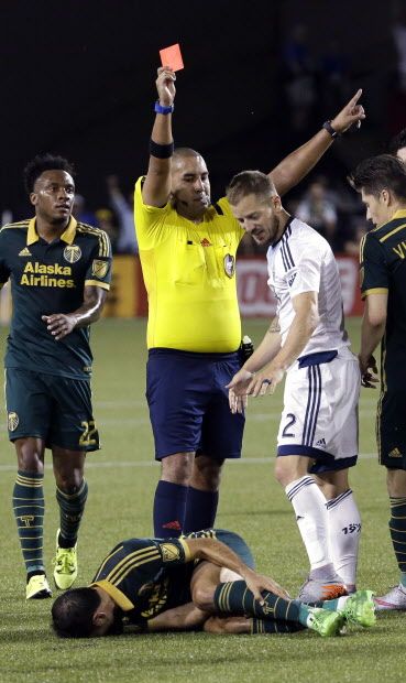 Vancouver Whitecaps defender Jordan Harvey, right, looks down at Portland Timbers midfielder Diego Valeri as he is given a red card during extra time of an MLS soccer match in Portland, Ore., Saturday, July 18, 2015. The teams tied 1-1. (AP Photo/Don Ryan)