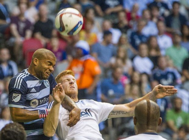 VANCOUVER, BC: July 12, 2015 -- Whitecaps Tim Parker, right battles for the ball with Sporting KC Kevin Ellis, left during the first half of a regular-season MLS match at BC Place Stadium in Vancouver, B.C. Sunday July 12, 2015.   (photo by Ric Ernst / PNG)  (Story by sports)  TRAX #: 00037667A & 00037667B [PNG Merlin Archive]