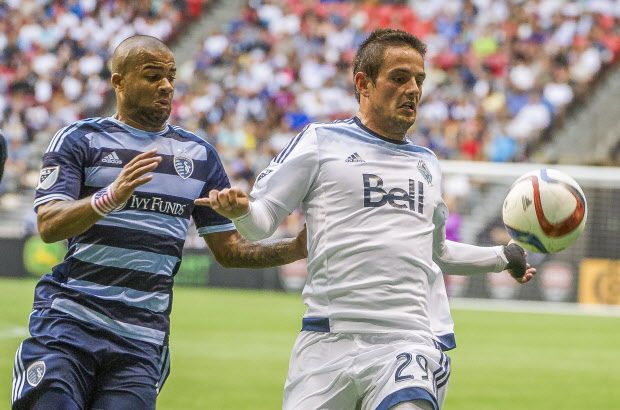 VANCOUVER, BC: July 12, 2015 -- Whitecaps Octavio Rivero, right battles for the ball with Sporting KC Kevin Ellis during the first half of a regular-season MLS match at BC Place Stadium in Vancouver, B.C. Sunday July 12, 2015.   (photo by Ric Ernst / PNG)  (Story by sports)  TRAX #: 00037667A & 00037667B [PNG Merlin Archive]