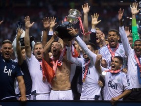 Vancouver Whitecaps players hoist the Voyageurs Cup trophy after defeating the Montreal Impact to win the Canadian Championship final soccer action in Vancouver, B.C., on Wednesday August 26, 2015. THE CANADIAN PRESS/Darryl Dyck