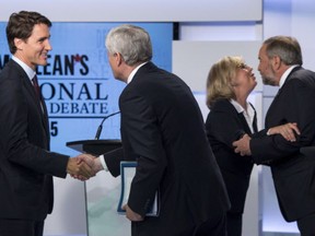 Liberal leader Justin Trudeau, left shakes hands with Conservative leader Stephen Harper as Green party leader Elizabeth May and NDP leader Thomas Mulcair embrace following the first leaders debate Thursday, August 6, 2015 in Toronto.  FRANK GUNN/AFP/Getty Images