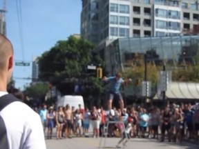 Busker Daniel Zindler is pictured here in a screen grab from a YouTube video taken in downtown Vancouver as he regains his balance after a kid interfered with his stunt.