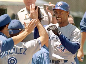 Toronto Blue Jays centre fielder Devon White is greeted by his teammates after White hit a solo home run off Oakland Athletics pitcher Ron Darling during the fourth inning  July 9, 1995 in Oakland, California. The Blue Jays defeated the Athletics 7-3.  (JOHN G. MABANGLO/AFP/Getty Images)