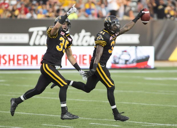 Hamilton Tiger-Cats defensive back Donald Washington (31) and defensive back Mike Daly (35) celebrate after Washington recovered a B.C. Lions fumble during the first half of CFL football action in Hamilton on Saturday, August 15, 2015. THE CANADIAN PRESS/Peter Power