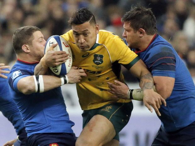 FILE - In this Nov. 15, 2014, file photo, Australia's Israel Folau, center, is tackled by France's Scott Spedding, left, and Prop Alexandre Menini during their rugby union international match at the Stade De France in Saint Denis, north of Paris. Fullback Folau made his name in rugby league when he broke the record for most tries in a debut season. His versatility and athletic prowess was such that Folau then accepted a lucrative deal to play Australian Rules, before switching - again - to rugby union in late 2012. (AP Photo/Francois Mori, File)