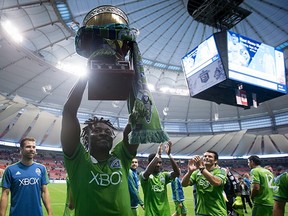 Seattle Sounders' Obafemi Martins hoists the Cascadia Cup. /9THE CANADIAN PRESS/Darryl Dyck)