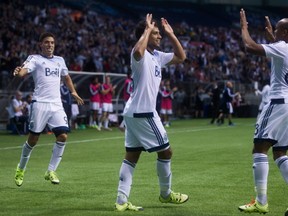 Vancouver Whitecaps' Nicolas Mezquida, Kianz Froese and Robert Earnshaw celebrate Froese's goal against C.D. Olimpia during the first half of a CONCACAF Champions League soccer game in Vancouver, B.C., on Wednesday September 16, 2015. THE CANADIAN PRESS/Darryl Dyck