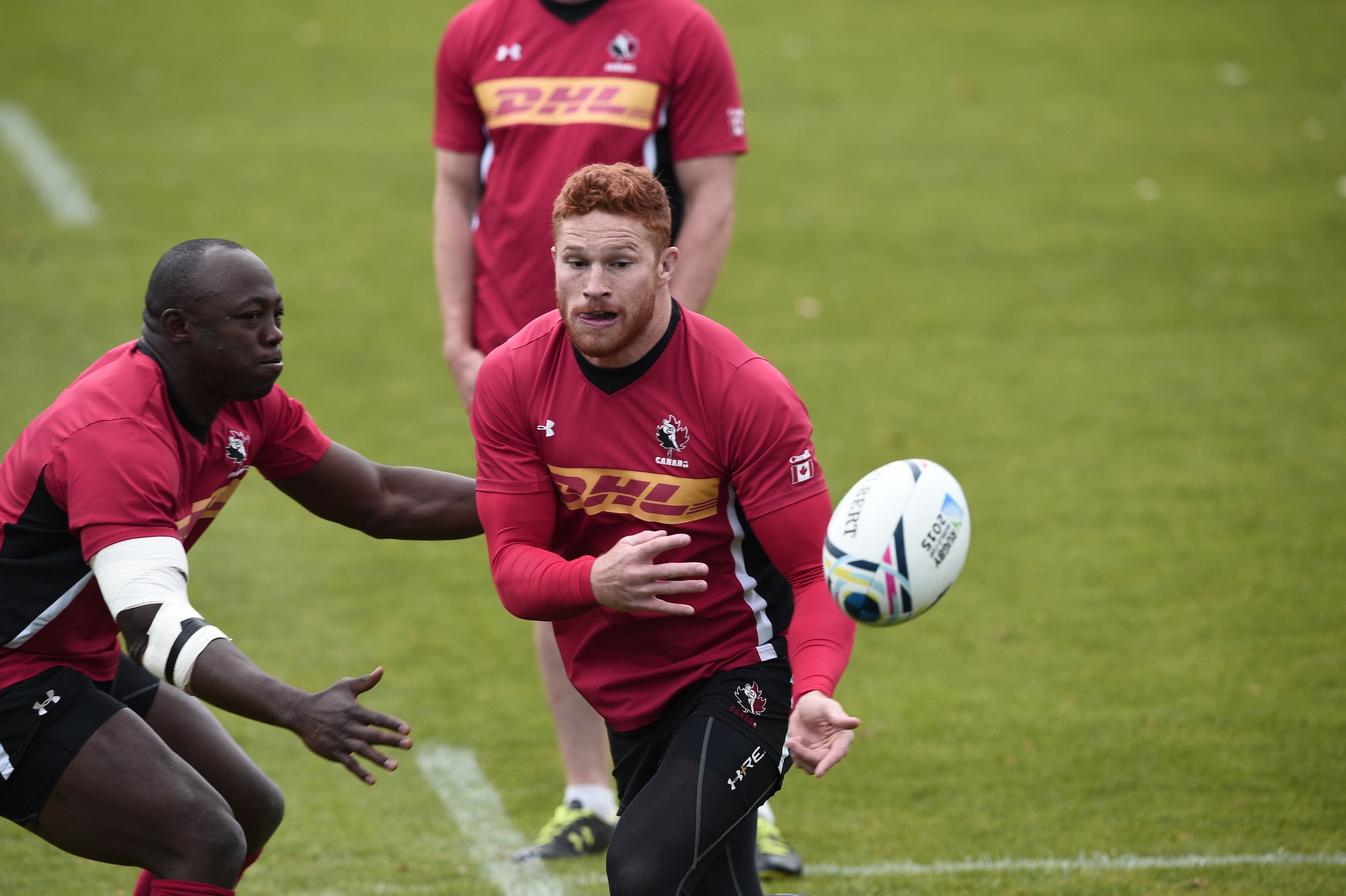 Canada's scrum-half Jamie Mackenzie (R) passes the ball next to Canada's flanker Nanyak Dala   during  a training session at Swansea university, on September 15, 2015, ahead of the 2015 Rugby Union World Cup. The 2015 Rugby World Cup starts on September 18.  AFP PHOTO / DAMIEN MEYER        (Photo credit should read DAMIEN MEYER/AFP/Getty Images)