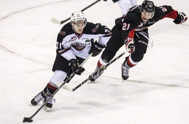 JANUARY  02 2015.  Vancouver Giants Brennan Menell skates away from Prince George Cougars Jared Bethune in WHL  action at Pacific Coliseum  in Vancouver,  B.C., on January 2, 2014.    (Steve Bosch  /  PNG staff photo)  00033911A [PNG Merlin Archive]